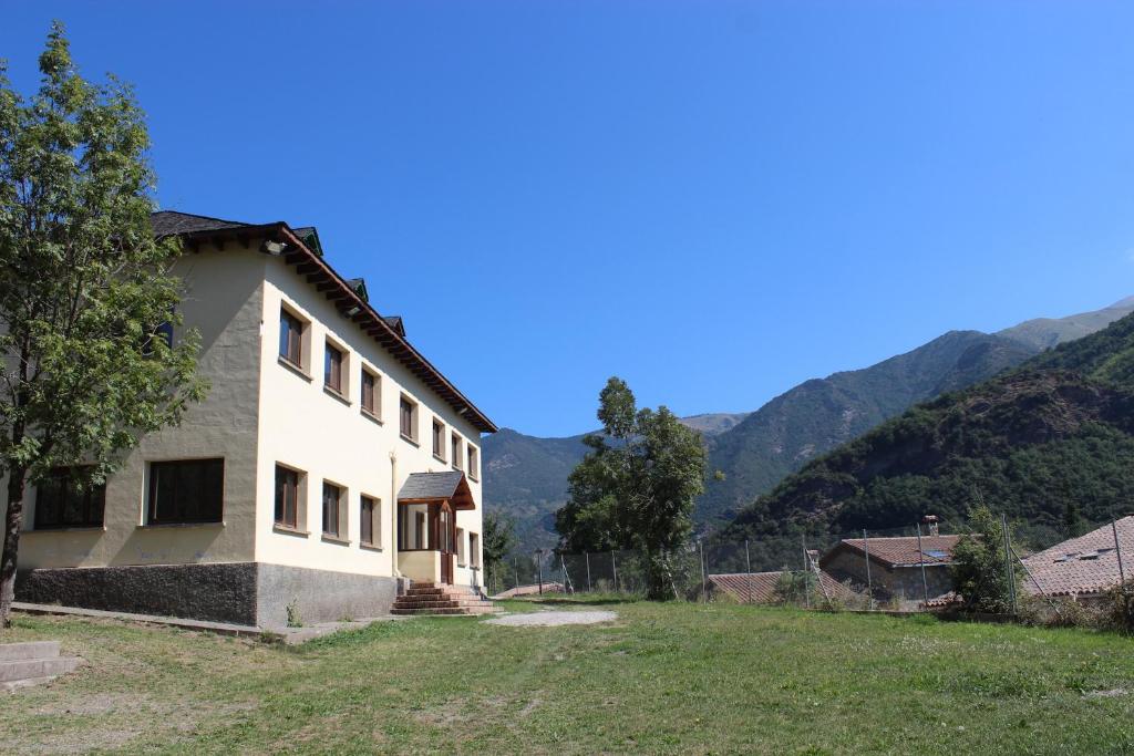 une maison dans un champ avec des montagnes en arrière-plan dans l'établissement Casa de Colònies Vall de Boí - Verge Blanca, à Llesp