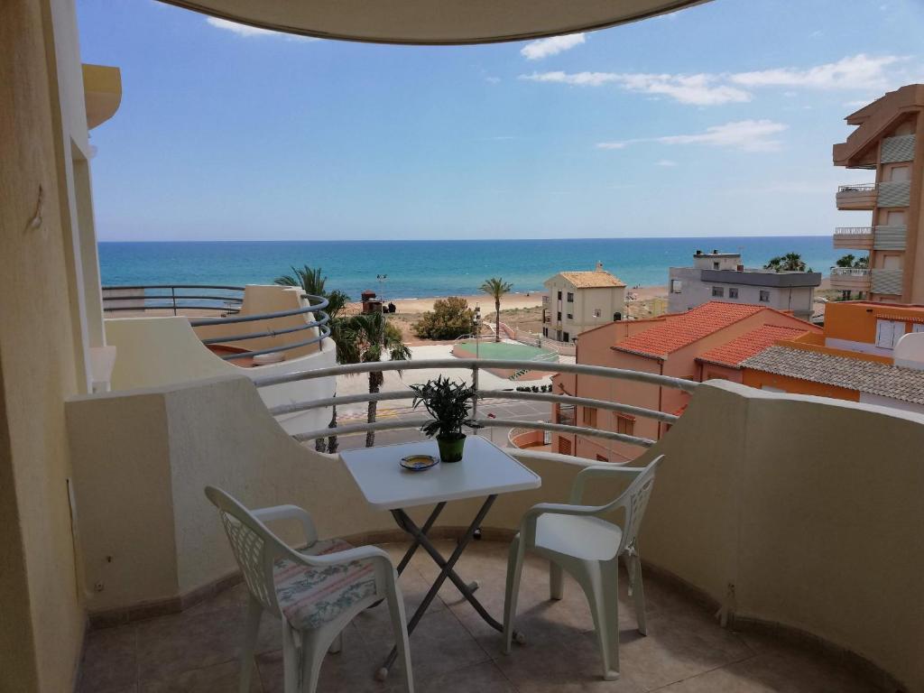 a balcony with a table and chairs and the ocean at Bitacora I Solo Familias Serviplaya!!! in Playa de Xeraco