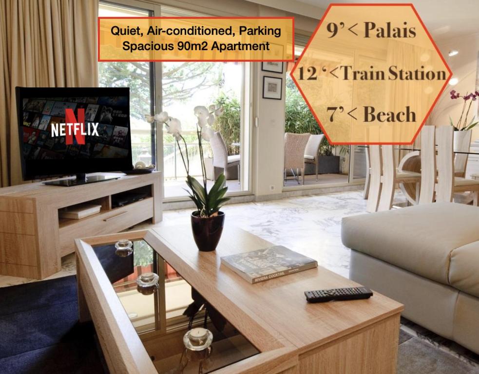un salon avec un canapé, une table et une télévision dans l'établissement 90m2 Apartement - Les Palmiers de Cannes, à Cannes