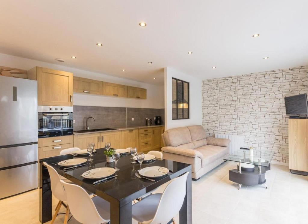 une cuisine et un salon avec une table et des chaises dans l'établissement Gites des falaises de Longues 6personnes, à Longues-sur-Mer