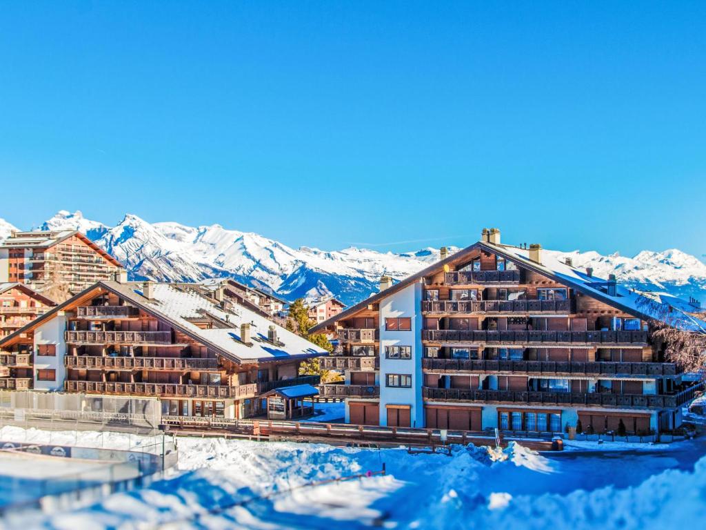 een hotel met sneeuw bedekte bergen op de achtergrond bij Apartment Lake Placid A7 by Interhome in Nendaz