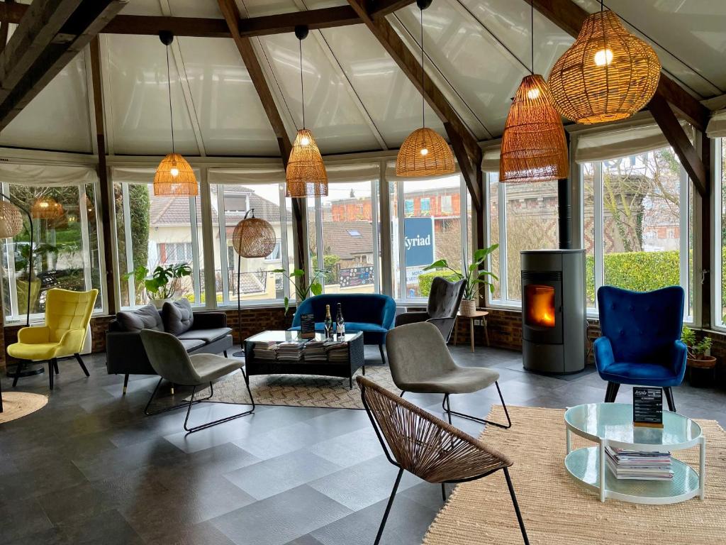 sala de estar amplia con sillas y chimenea en Kyriad Epernay, en Épernay