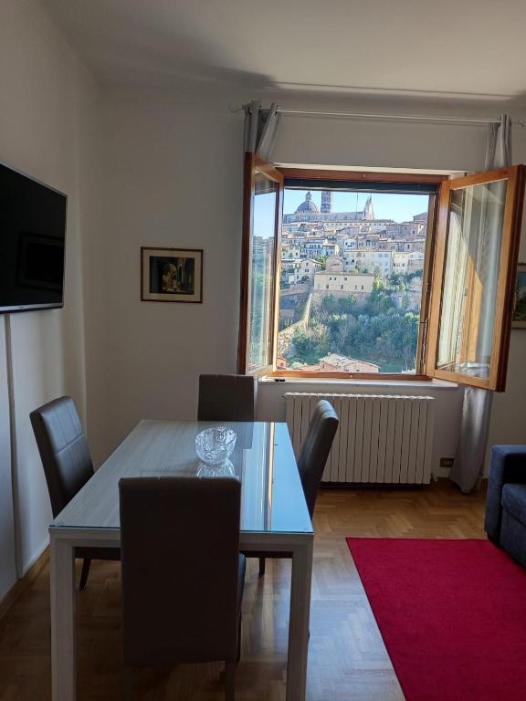 jadalnia ze stołem i dużym oknem w obiekcie La Finestra su Siena w Sienie