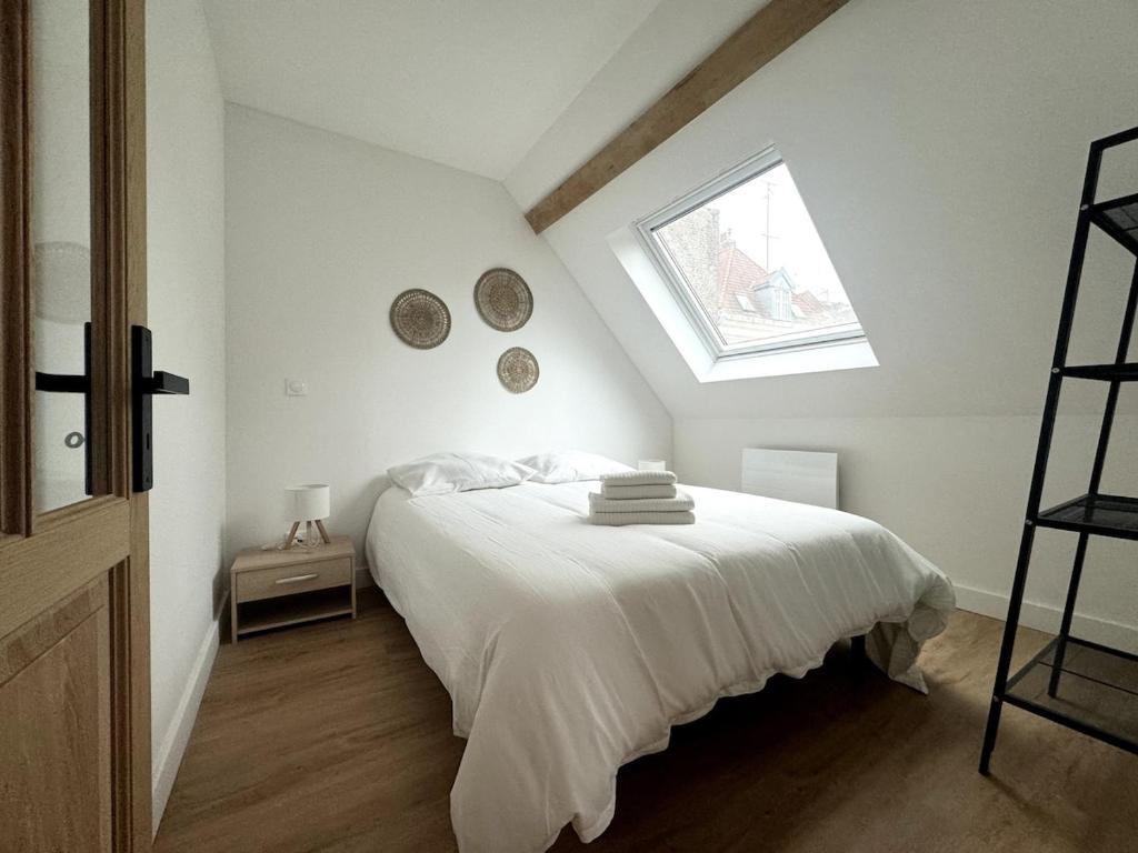 une chambre avec un grand lit blanc avec une fenêtre dans l'établissement Le Grenier de la Grappe 2, à Lille