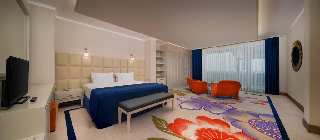 a bedroom with a bed and a tv in a room at Pine Beach Belek in Belek