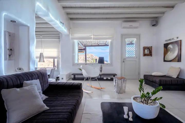 a living room with a black couch and a table at Nimbus My Aktis in Super Paradise Beach
