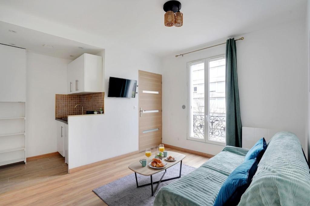 un salon avec un canapé et une table dans l'établissement Apartment Suite 33 Au Portes de PAris, à Aubervilliers