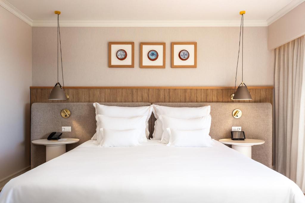 a bedroom with a large bed with white pillows at Grande Real Santa Eulalia Resort & Hotel Spa in Albufeira