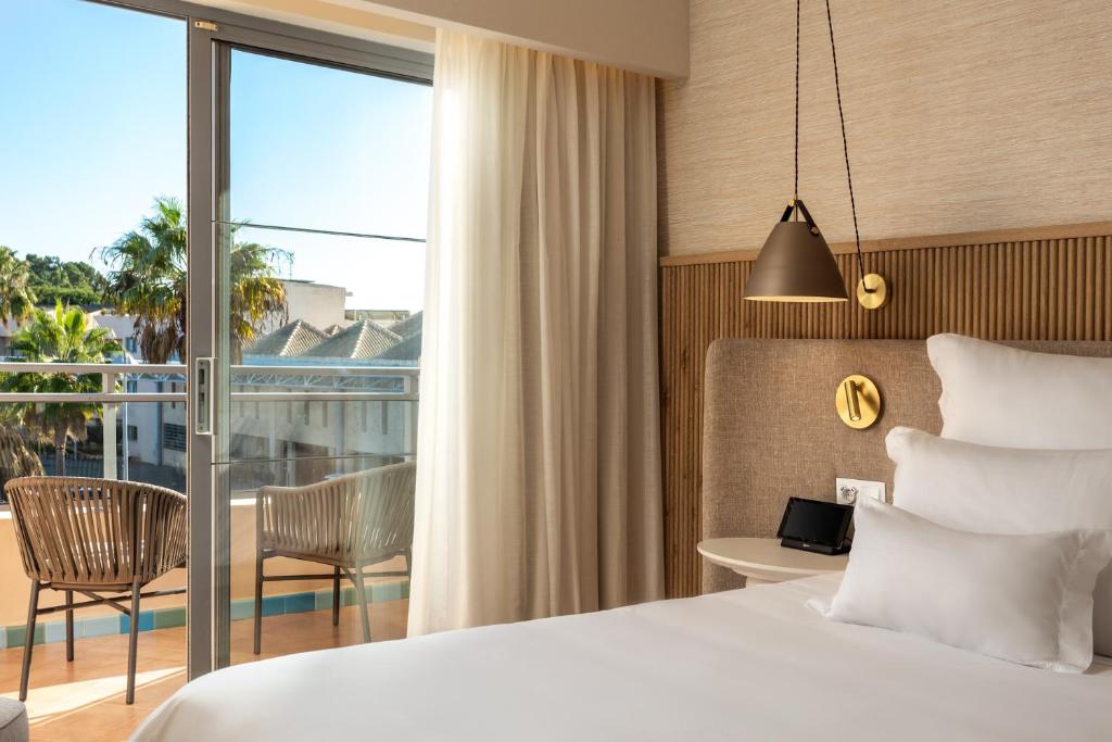 a hotel room with a bed and a balcony at Grande Real Santa Eulalia Resort & Hotel Spa in Albufeira