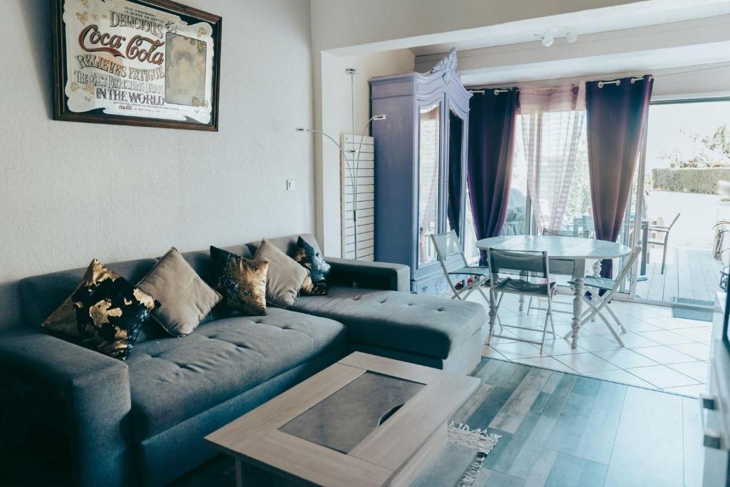 un salon avec un canapé et une table dans l'établissement Naturiste Cap d'Agde Villa Héliovillage 39, au Cap d'Agde