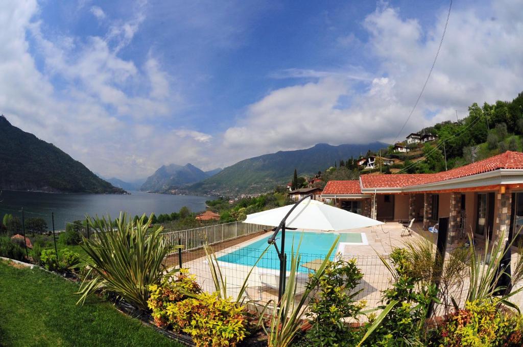 uma casa com piscina ao lado de um lago em Agriturismo Le Fontane em Sale Marasino