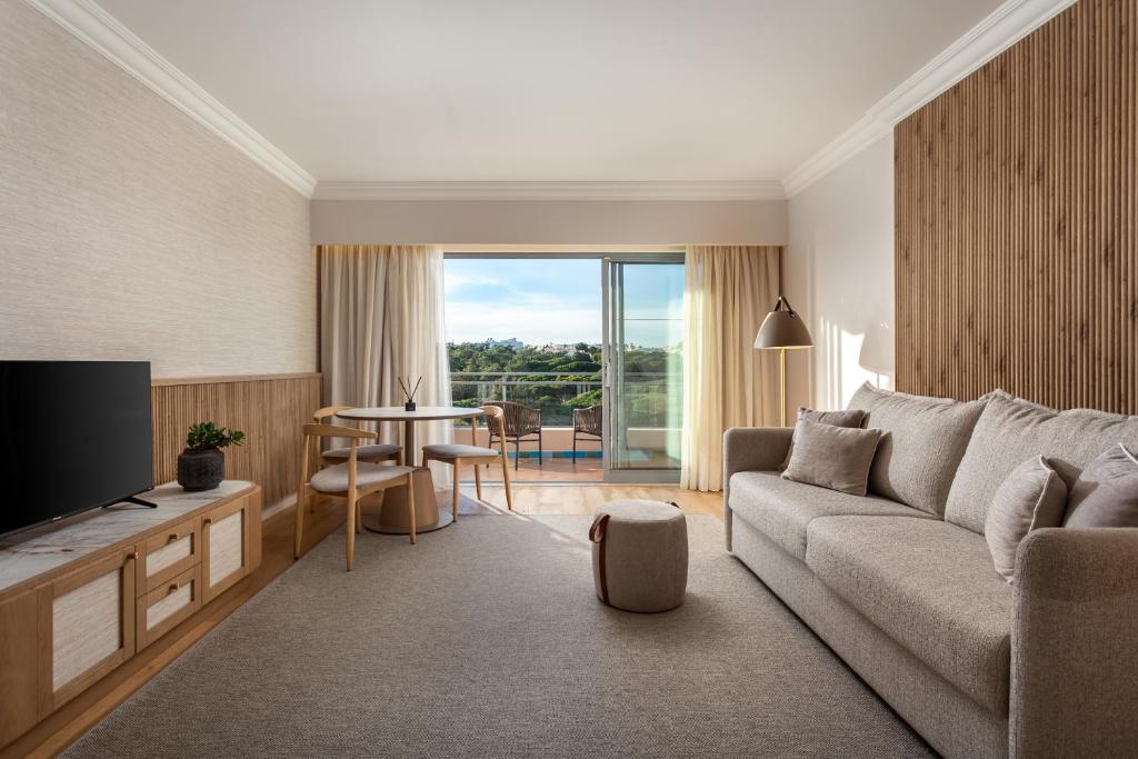 a living room with a couch and a table at Grande Real Santa Eulalia Resort & Hotel Spa in Albufeira