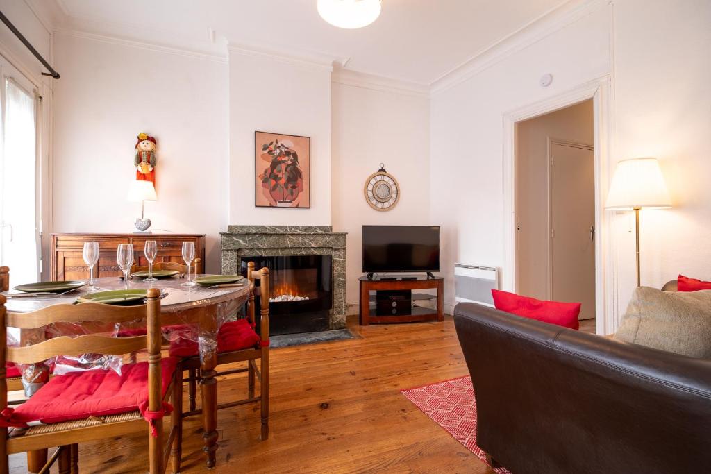 a living room with a table and a fireplace at Joli T2 BAGNERES de Bigorre Centre in Bagnères-de-Bigorre