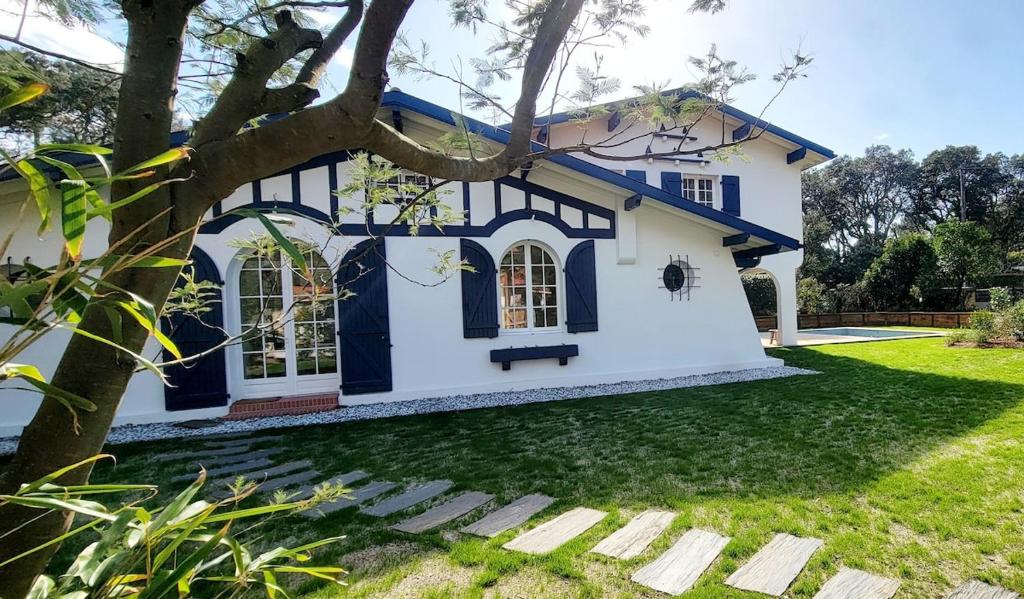 une maison bleue et blanche avec un arbre dans l'établissement Villa - Libellules - Emplacement Prenium, à Hossegor