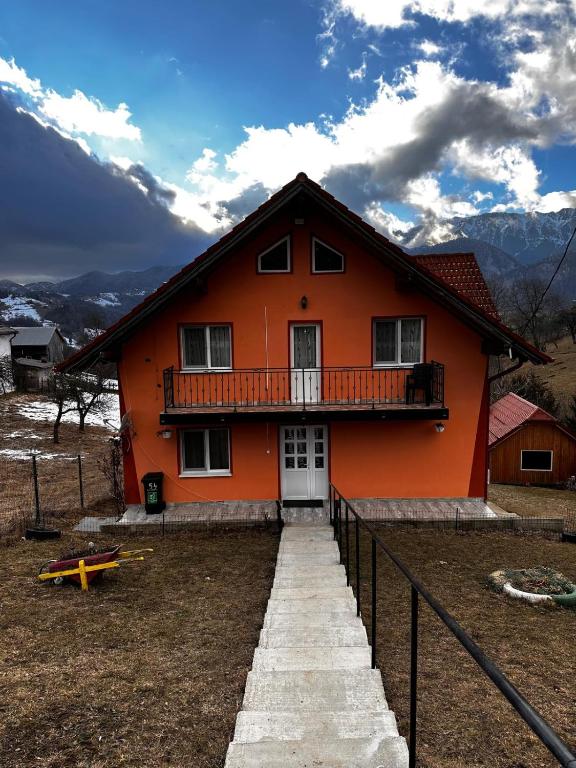 una casa arancione con un balcone in cima di Dor de munte a Măgura