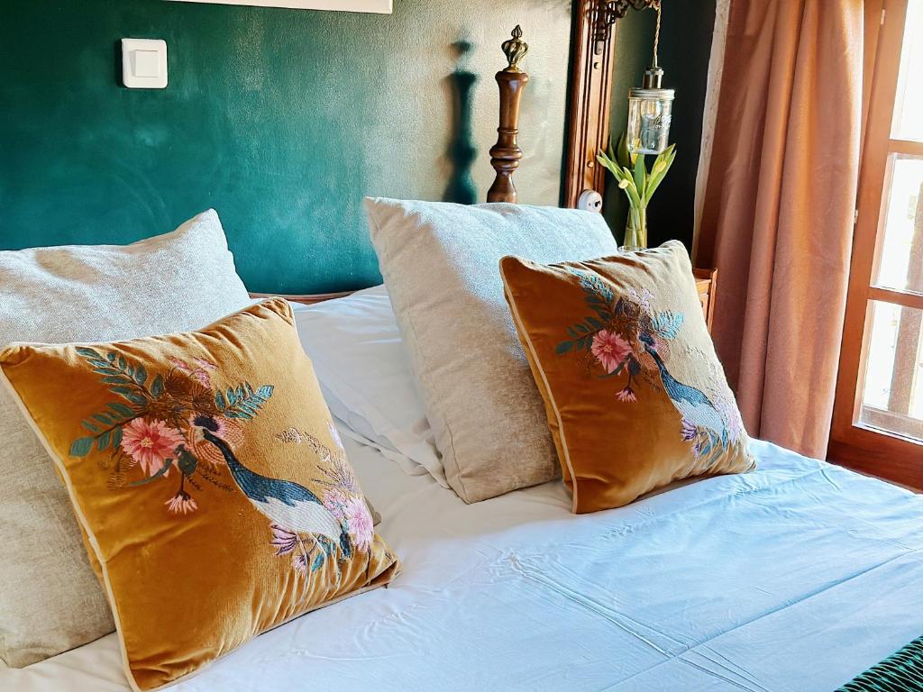 een bed met drie kussens erop bij Le Chevrefeuille chambres d'hotes et gîtes de charme in Meyrals