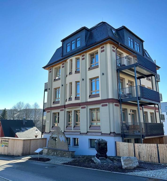a large white building with a black roof at Urlaubshaus-Erzgebirge in Zwönitz