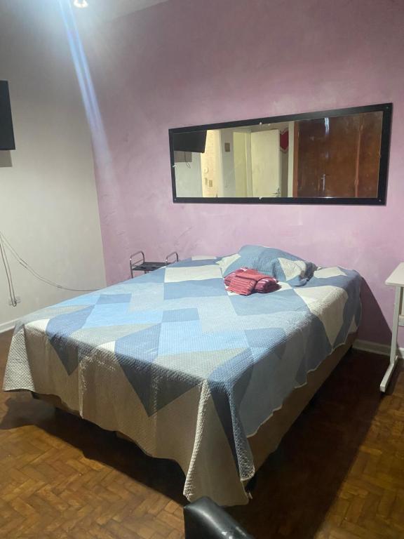 a bed in a room with a mirror on the wall at Edículas da vivi in Sao Paulo