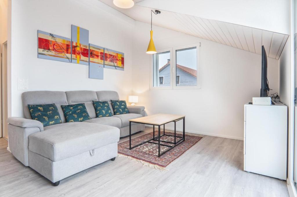 ein Wohnzimmer mit einer Couch und einem Tisch in der Unterkunft Semsales, relaxing and quiet in Semsales