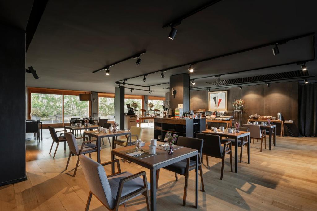 Un restaurante con mesas y sillas en una habitación. en Eurostars Pamplona, en Pamplona