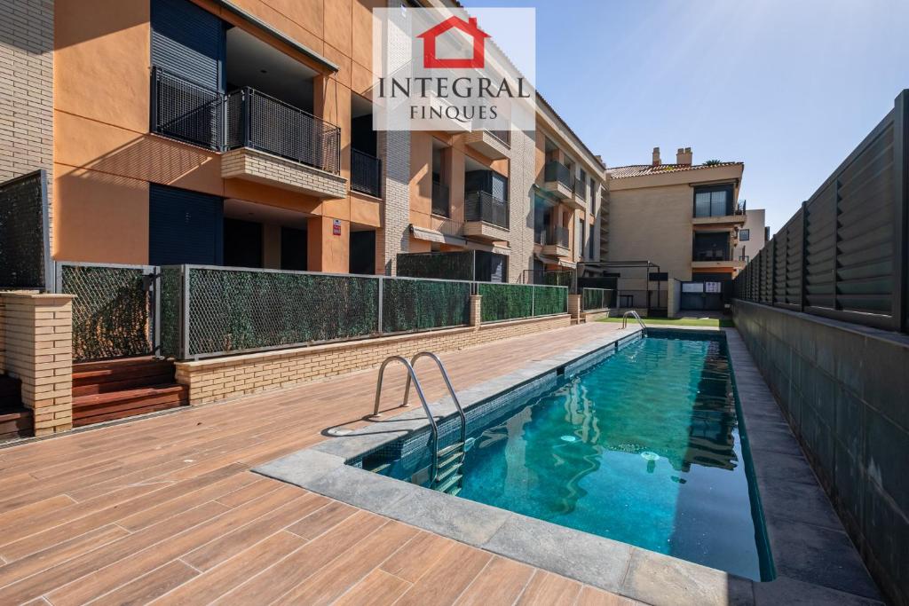 a swimming pool in front of a building at Apartament Cel Blau in Palamós