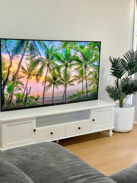 a flat screen tv sitting on a white entertainment center at Cloverton Escape Retreat in Kalkallo