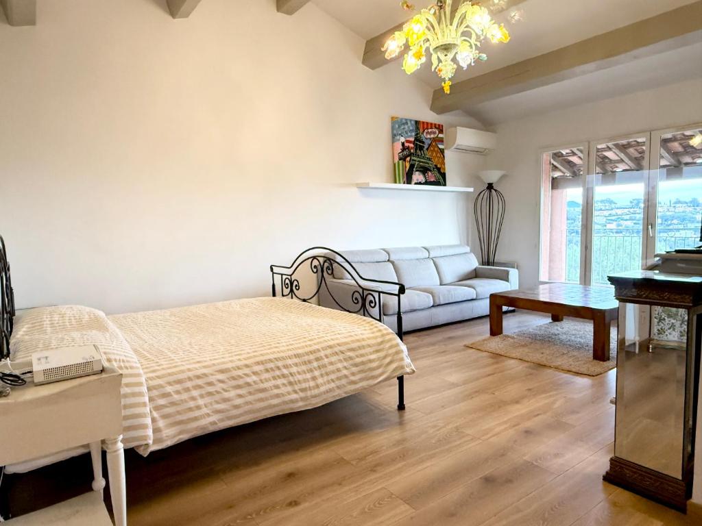 a bedroom with a bed and a couch at Magnifique Studio Cagnes Sur Mer in Cagnes-sur-Mer