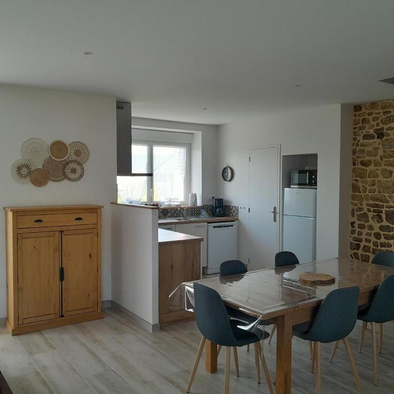une cuisine avec une table et des chaises dans une pièce dans l'établissement La Grange aux Abeilles 3, à Saint-Senier-sous-Avranches