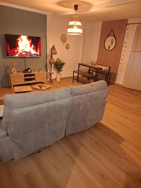 - un salon avec un canapé gris et une télévision dans l'établissement Charmant T2 en Périgord, à Périgueux