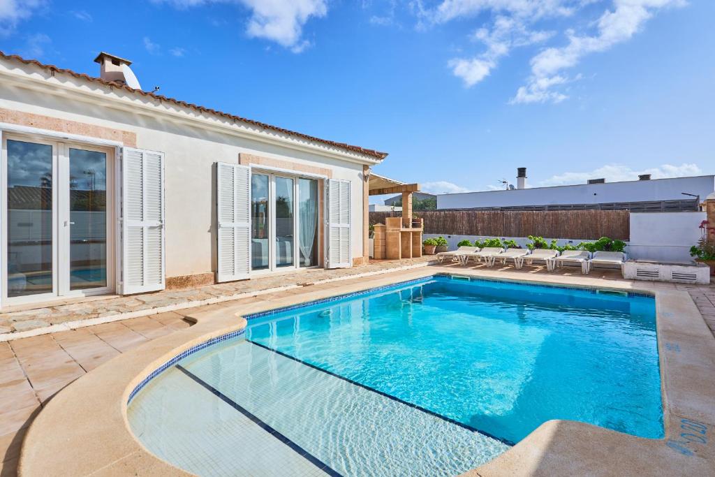 a swimming pool in the backyard of a house at Villa Martin in Portocolom