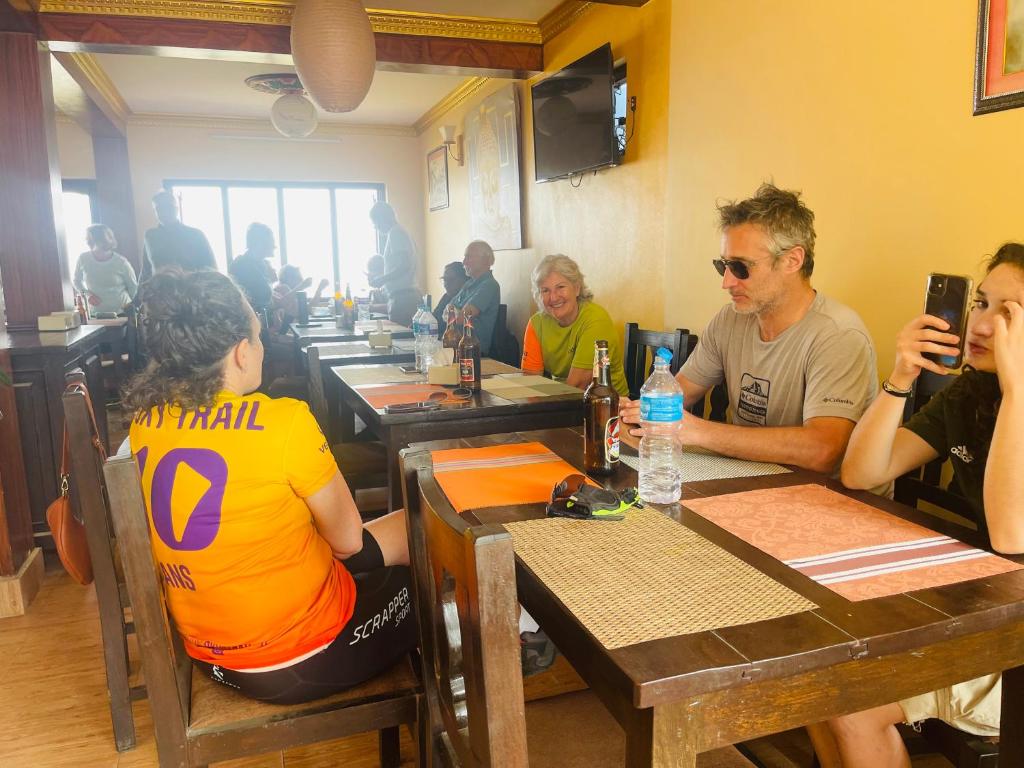 a group of people sitting at tables in a restaurant at Hotel Everest Window View in Nagarkot