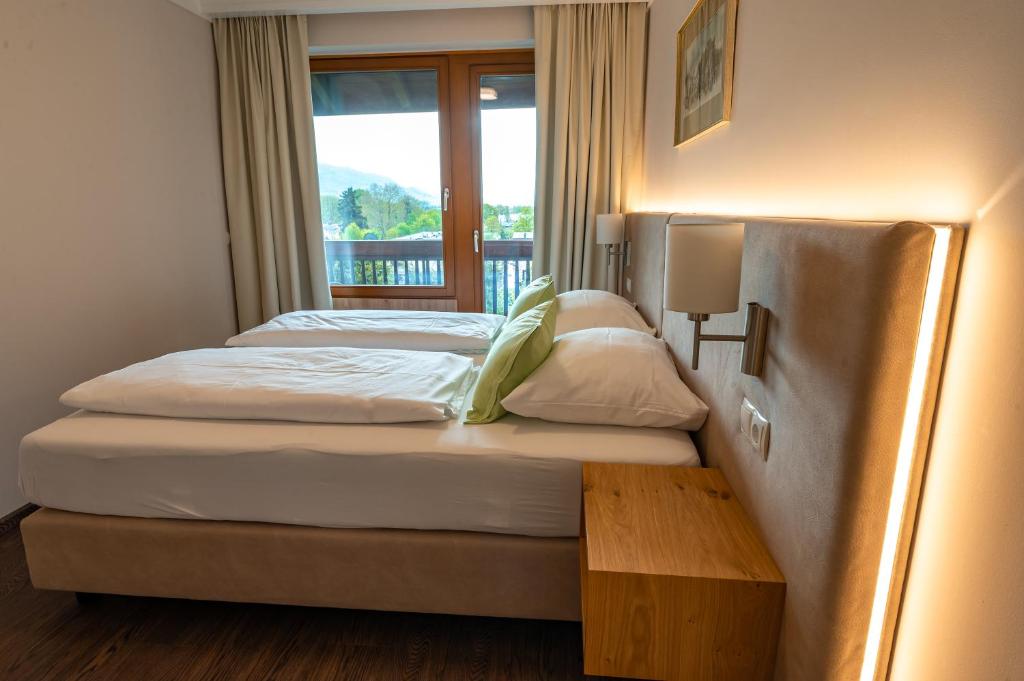łóżko w pokoju z oknem i łóżko sidx sidx sidx w obiekcie Hotel Haus Arenberg w mieście Salzburg