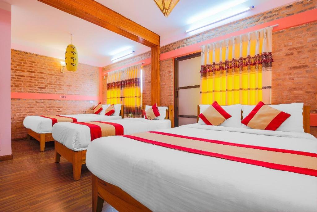 a hotel room with three beds in a room at Hotel Everest Window View in Nagarkot