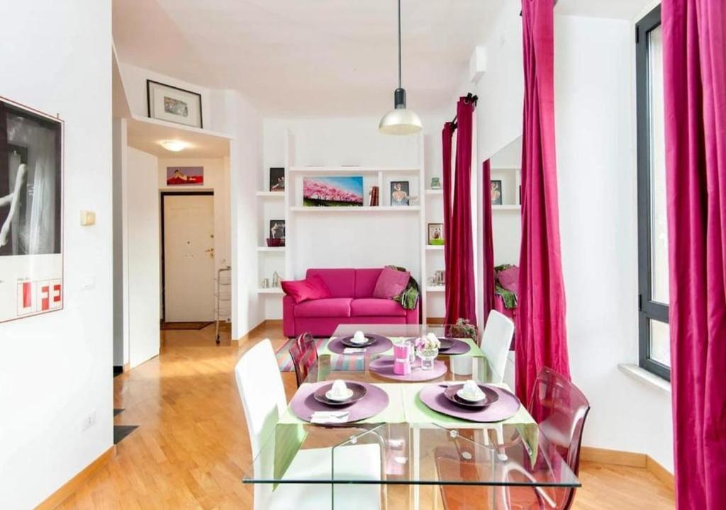 a living room with a pink couch and a glass table at LoL-ApartmenT, in the heart of Trastevere in Rome