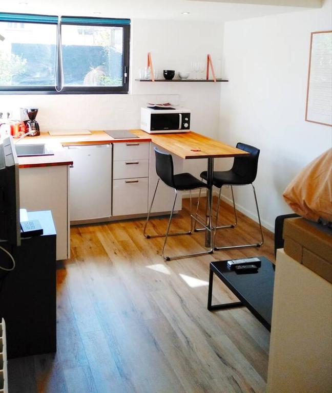 une petite cuisine avec une table et deux chaises dans l'établissement Ma Cabane Jardin en Ville, à Rennes