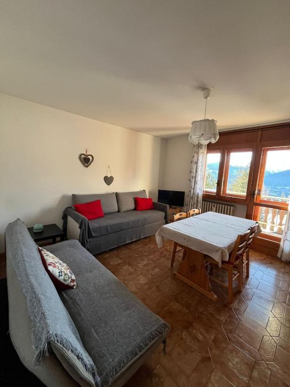 ein Wohnzimmer mit Sofa und Tisch in der Unterkunft Casa vacanze la primula erro in Sauze d'Oulx
