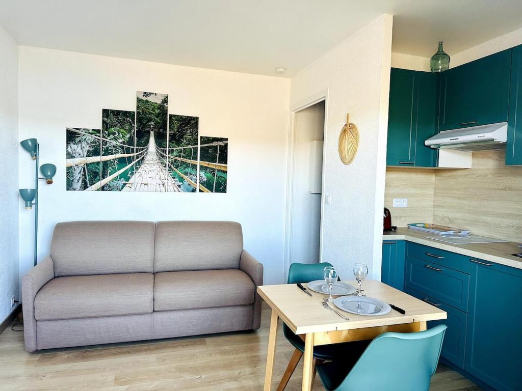 un salon avec une table et un canapé dans une cuisine dans l'établissement Les balcons du Lac - Studio Belle Vue, aux Salles-sur-Verdon
