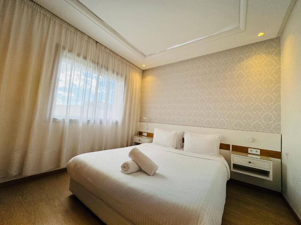 een slaapkamer met een groot wit bed en een raam bij Modern Apartment in the heart of Tangier in Tanger