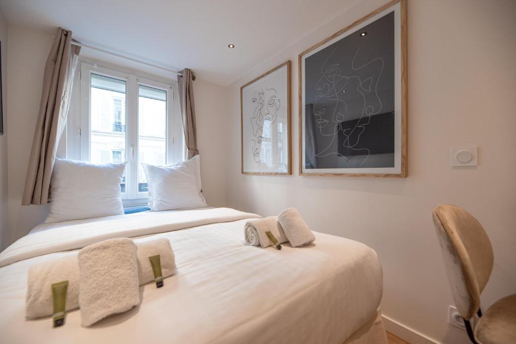 une chambre avec deux lits et une fenêtre dans l'établissement CIA - Studio Pierre Fontaine, à Paris