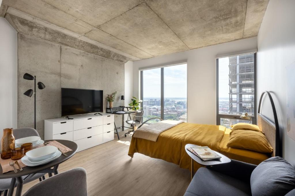 a bedroom with a large bed and a large window at Appartements Dorchester in Montreal