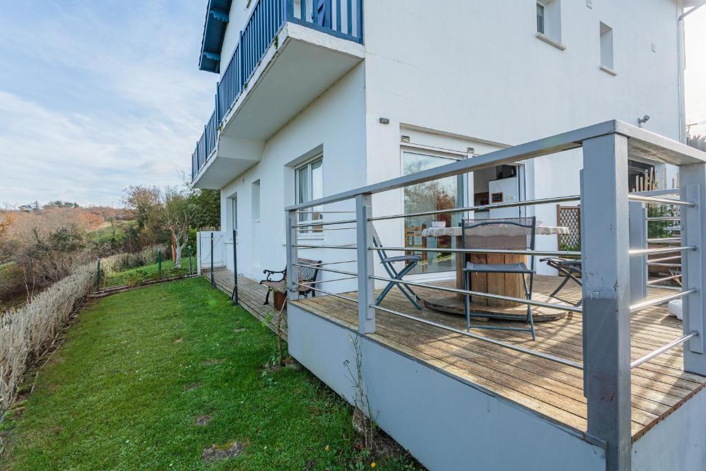 - un balcon d'une maison avec une terrasse en bois dans l'établissement Artzain appartement au calme à mi chemin entre la mer et la campagne, à Urrugne