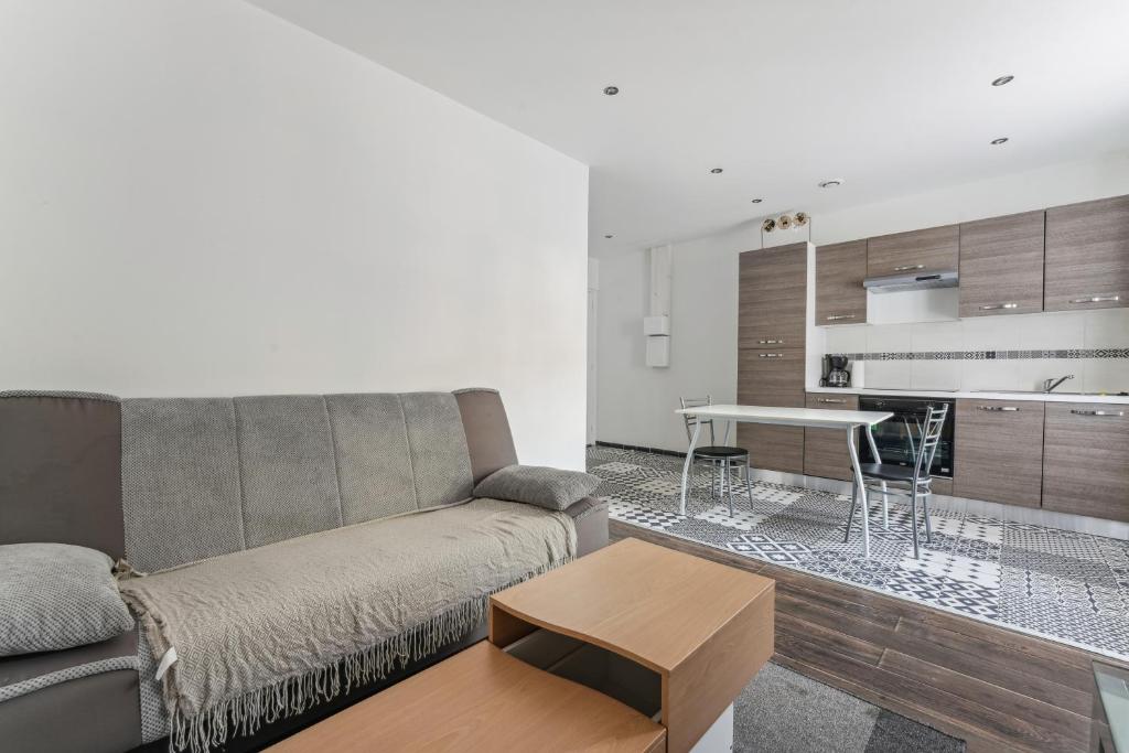 un salon avec un canapé et une table dans l'établissement Budget appart avec parking au centre-ville, à Charleville-Mézières