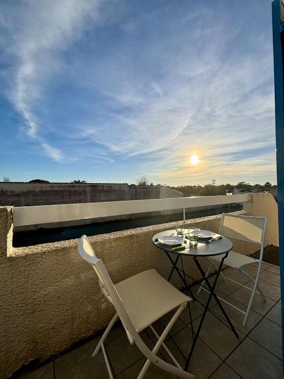 un patio avec une table et des chaises sur un balcon dans l'établissement Appartement 2 pièces 4 couchages Dolus d'Oléron DDO000-085, à Dolus-d'Oléron