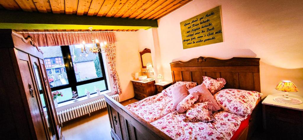 Un dormitorio con una cama con almohadas rosas y una ventana. en Nertha, die Ferienwohnung, en Uslar