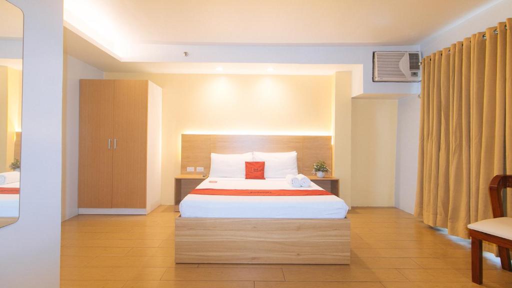 Postel nebo postele na pokoji v ubytování RedDoorz at LuxeLite Suites Makati