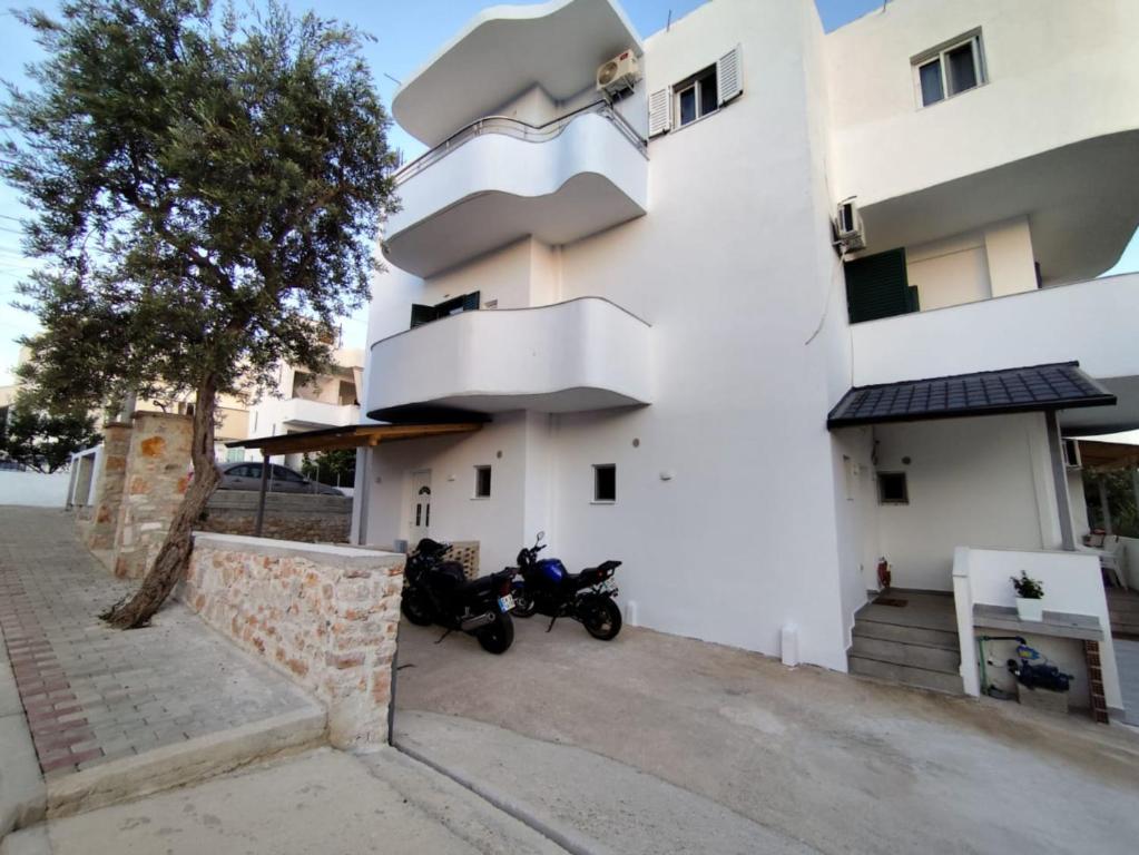 a motorcycle parked in front of a white building at M&J Home in Ksamil
