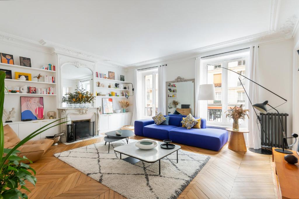 un salon avec un canapé bleu et une table dans l'établissement Magnifique appartement 135m2 Jardin du Luxembourg, à Paris