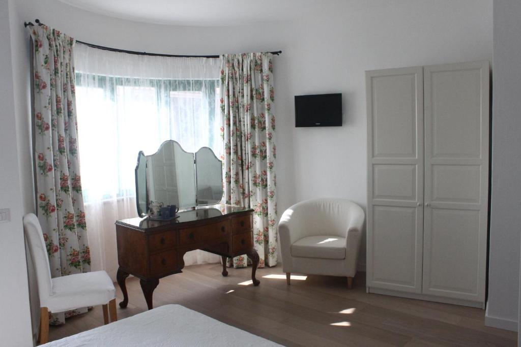 1 dormitorio con tocador, espejo y silla en La Fonda, en Palau