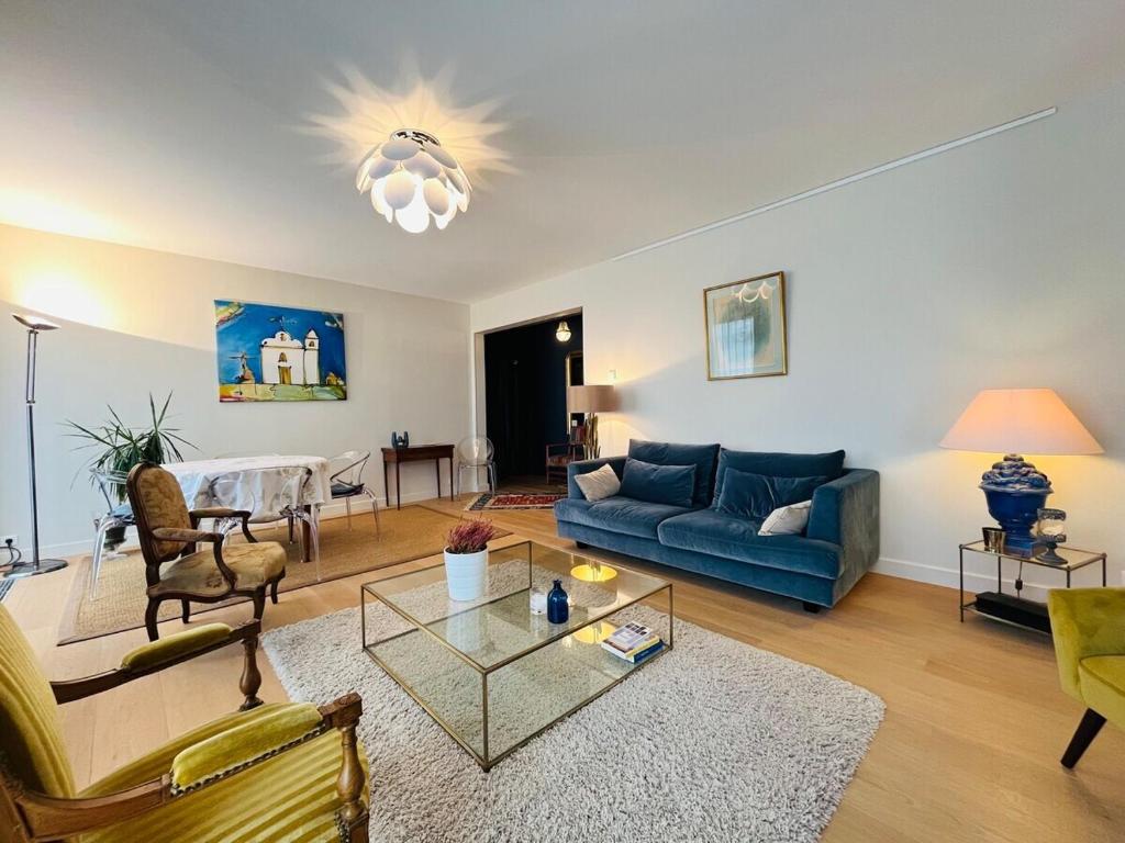 un salon avec un canapé bleu et une table dans l'établissement Casa Quinconce, à Angers