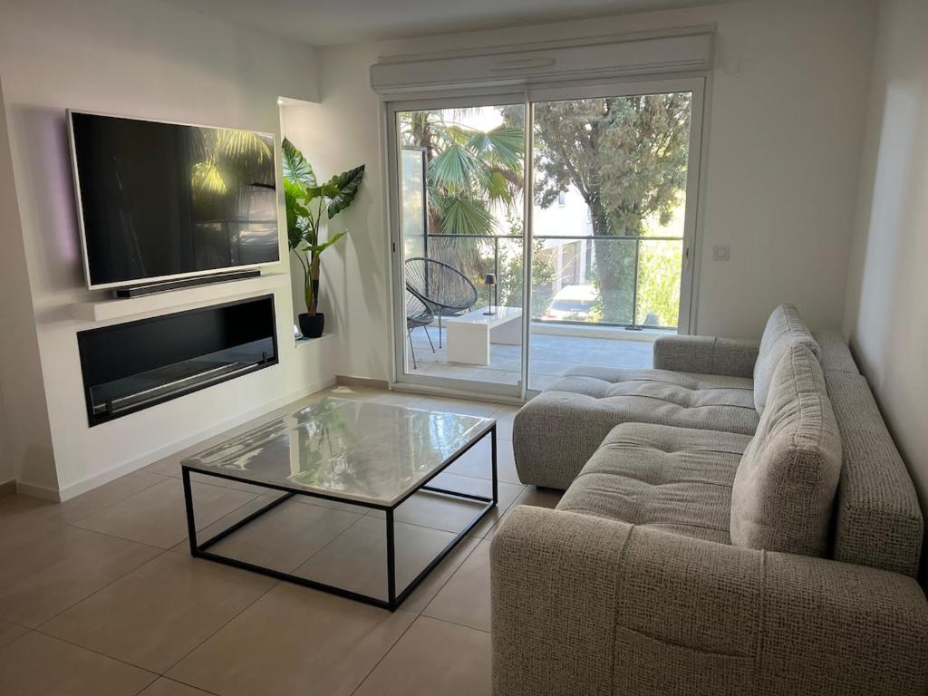un salon avec un canapé et une table basse en verre dans l'établissement 2 Bedroom Apartment Near Beach, à Mandelieu-la-Napoule